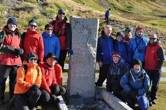 Passengers posing on Ernest Shackleton’s graveside in Grytviken in South Georgia during the voyage.