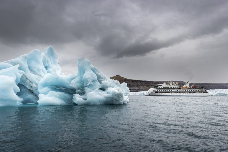 Ship cruising by a massive glacier in Croker Bay