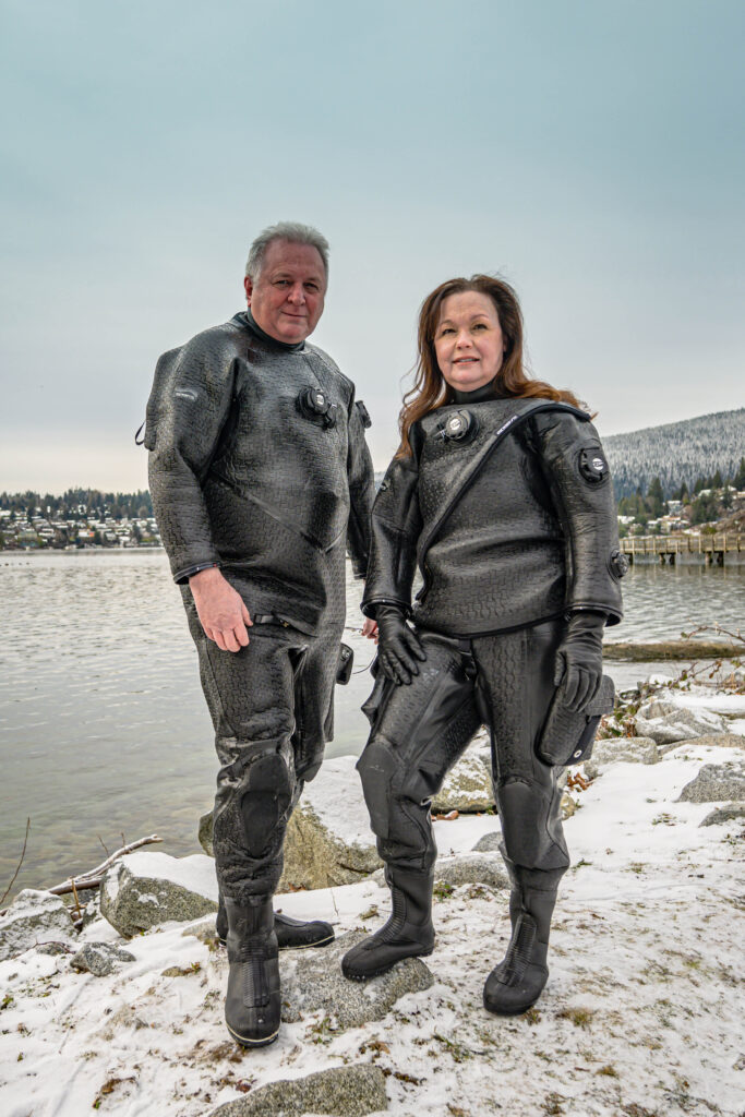Jett and Kathryn Britnell in diving suits by the water
